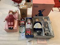 Overall view of five dolls including boxed and certificate items with some dolls in display stands