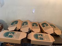 Seven original archival storage boxes with the Valerie doll logo and branding from Under the Big Top Collection by Chris Miller, closed and stacked showing box designs.