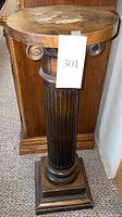 Full front view of the pedestal showing the round top, fluted column, and square base with the auction lot tag.