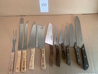 Photo showing 9 cutting utensils including steak fork, paring knives, and cleavers with wooden handles