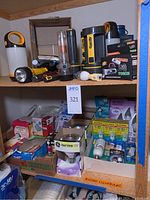 Shelf with assorted flashlights, lanterns, and boxed lightbulbs