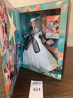 Side view of the doll in original display box with blue background and Gone with the Wind movie poster inside