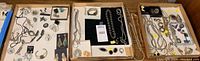 Three trays showing assorted silver jewelry: earrings, bracelets, rings, necklaces
