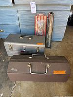 Photo showing two Craftsman toolboxes, one silver and one brown, with hand tools inside and packaging visible in the background.