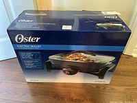 Original box showing Oster branding and product image of the electric skillet with removable pan.