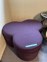 Front top view of purple clover-shaped ottoman showing three joined circular sections and fabric detail.