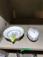 Photo of Sadler porcelain egg and candy dish on a shelf, showcasing floral designs and white porcelain finish.