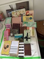Overview of multiple stationery items including journals, notebooks, and notecards arranged on table surface.