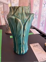 Front view of green drip glazed ceramic vase with leaf-like relief design