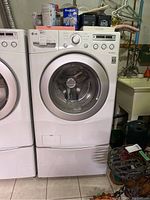 Full front view of LG washer on pedestal in basement