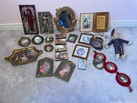 Wide view showing all art miniatures, framed prints, mirror, miniature plates, and fabric doll laid on carpet.
