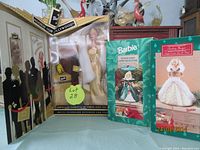 Boxed 2002 Barbie 'Hooray for Hollywood' doll alongside two Hallmark Barbie stocking hangers from 1995 and 1996, showing front and side of boxes.