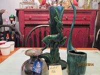 Photo showing the four vases: the tall green Swan vase, tall Deer vase, smaller brown vase with wide mouth, and Studio Line vase with narrow neck.