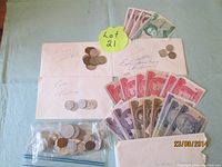 Photo of envelopes with assorted coins and banknotes arranged around the envelopes.