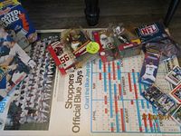 Photo showing the 1981 Toronto Blue Jays calendar, two MacFarlane NFL football figures, assorted cards, and NFL scarf, all arranged on a table.