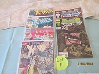 Six comic books laid on a flat surface, showing front covers including 4 X-Men and 2 Punisher War Zone issues.