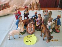 Vintage nativity scene set figurines arranged on table showing whole group including animals, angels, wise men and Holy Family.