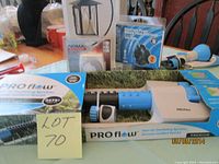 Photo showing ProFlow oscillating sprinkler, blue watering wand, and NOMA fountain pump package with lot label.