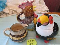 Three ceramic items displayed: Royal Doulton Deadwood pitcher, vintage toucan cookie jar, Italian rooster pitcher