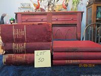 Wide shot showing all six statute books, three large and three smaller, with significant wear on larger volumes.