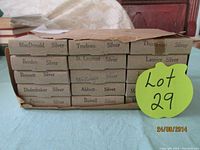 Photo of stacked original beige cardboard boxes labeled with the names of Canadian Prime Ministers, each containing a silver spoon. Labels include MacDonald, Trudeau, St. Laurent, Thompson, Bowden, Laurier, Bennett, Mackenzie, Abbott, Diefenbaker, Pearson, Bowell.