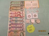 Photo showing Canadian banknotes arranged from $1 to $20 denominations along with loose coins and US coins grouped nearby.