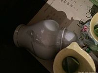 White ceramic urn with lid, smooth and plain with vintage wear.