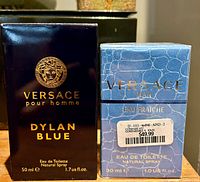Front view of the two boxes: Versace Dylan Blue 50 ml and Versace Man Eau Fraiche 30 ml with price sticker.