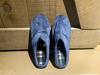 Top view of the blue plush slippers showing soft exterior and plaid lined interior