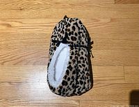 Top view of one slipper showing cheetah print fabric and black ribbon bow detail