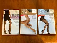 Front view of three packages of women's sheer nylons pantyhose showing brand and style details.