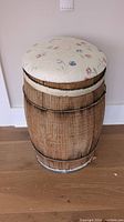 Wooden barrel with floral cushioned top showing slight wear and loose top metal ring.