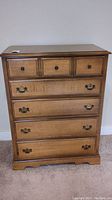 Front view of wood chest of drawers showing drawer arrangement and condition