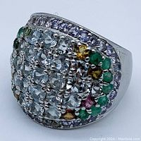 Top view of the ring showing a rectangular cluster of round-cut aquamarine stones surrounded by emerald, tanzanite, and orange-yellow stones in a 925 sterling silver setting with 14K gold plating.