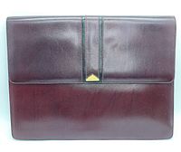 Front side view of the Bally leather briefcase clutch bag showing the smooth burgundy leather with central embossed section and Bally logo plaque.