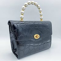 Side angle showing the croc embossed texture and pearl handle