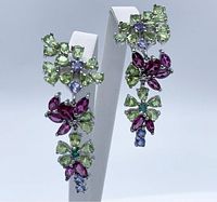 Front view of the earrings showing pear-cut green peridot, marquise rhodolite, and smaller blue stones set on silver with gold plating.