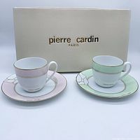 Front view of the two Pierre Cardin cups and saucers with their box in the background