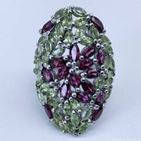 Front view of ring showing marquise cut rhodolite garnet and peridot stones arranged in a lattice pattern with a marquise shape top on a 925 sterling silver base.