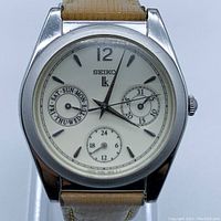 Front view of the Seiko Lukia quartz wristwatch showing cream dial, silver markers, and subdials for day, date, and 24-hour time.