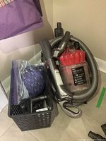 Full kit showing Dyson DC32 canister vacuum with hoses and attached power head, accessories in a basket