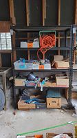 Full view of the large black metal shelving unit with various boxes and items on the shelves, showing shelf structure and location in garage.