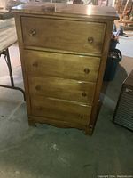 Front view of vintage highboy dresser with four drawers, showing wood finish and round wooden knobs.