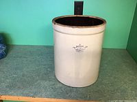 Full front view of the vintage stoneware crock showing overall shape, color, and condition.