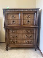 Front view of Kaufman wood dresser showing upper two drawers with ring pulls and lower three drawers with ornate handles, decorative top molding, wood grain finish.