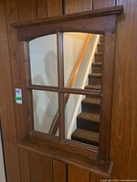 Front view of the wood-framed mirror showing four divided glass panes and top molding.