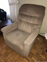 Brown fabric recliner chair with high back and padded arms, showing front-side angle.