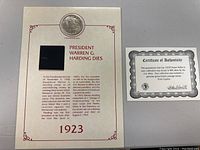 Coin embedded in display card with historical information about President Warren G. Harding's death in 1923 and a certificate of authenticity.