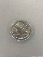 Obverse side of 1924 Peace Silver Dollar coin showing Lady Liberty and the year 1924, encased in clear plastic round protective case.