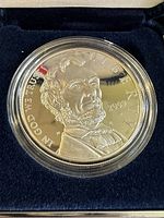 Close-up photo of the 2009 Abraham Lincoln commemorative proof silver dollar showing the detailed portrait of Abraham Lincoln with inscriptions 'IN GOD WE TRUST', 'LIBERTY', and '2009'. Coin is inside a clear protective plastic case.